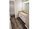 Bright bathroom featuring a granite countertop vanity, wood-look flooring, and a tiled tub and shower combo at 381 Fleming Ct, Jonesboro, GA 30238
