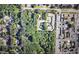 Aerial view showcases a wooded lot surrounded by homes, apartment complexes, and commercial streets at 5655 Lake Forrest Dr, Atlanta, GA 30342