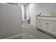Bathroom with a white vanity and toilet sits on light gray tile flooring at 5655 Lake Forrest Dr, Atlanta, GA 30342