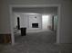Empty living room with black fireplace, white walls, and rough concrete flooring at 5655 Lake Forrest Dr, Atlanta, GA 30342