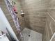 Close-up of tile shower with horizontally stacked tiles and neutral-colored shower curtain at 5655 Lake Forrest Dr, Atlanta, GA 30342