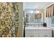 Well-lit bathroom with a single vanity, marble countertops, and decorative shower curtain at 725 Brown Pl, Decatur, GA 30030