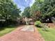 Quaint brick home with mature trees, a brick driveway, and lush landscaping at 725 Brown Pl, Decatur, GA 30030