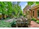 A beautiful backyard and patio with an outdoor dining area, fire pit, and lush landscaping at 1676 Grove Park Way, Decatur, GA 30033
