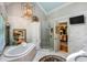 Spacious bathroom with marble tiling, a soaking tub, and a glass shower enclosure at 1676 Grove Park Way, Decatur, GA 30033