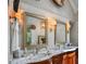 Bathroom featuring a double vanity with a marble countertop and two decorative mirrors with sconces at 1676 Grove Park Way, Decatur, GA 30033