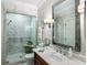 Bathroom with a glass-enclosed shower, marble-style tiling, and dark wood vanity at 1676 Grove Park Way, Decatur, GA 30033