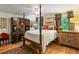 This bedroom features a four-poster bed, wood floors, and a built-in cabinet with drawers at 1676 Grove Park Way, Decatur, GA 30033
