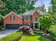Lovely brick home featuring mature trees and manicured shrubs provides exceptional curb appeal at 1676 Grove Park Way, Decatur, GA 30033
