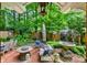 Outdoor patio with lounge area, dining table, fire pit, fountain, and lush landscaping at 1676 Grove Park Way, Decatur, GA 30033