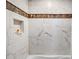 Shower with white and tan marble-look tile with a built-in shelf at 1676 Grove Park Way, Decatur, GA 30033