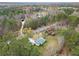 Aerial view of house surrounded by lush trees and a winding path to a detached garage or shed at 1892 Buford Dam Rd, Buford, GA 30518