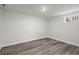 Unfinished basement with gray wood floors and one window at 1892 Buford Dam Rd, Buford, GA 30518