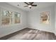 Bright bedroom with multiple windows, ceiling fan, and hardwood floors at 1892 Buford Dam Rd, Buford, GA 30518