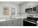 Bright kitchen showcasing stainless steel appliances, sleek countertops, and modern gray cabinetry at 1892 Buford Dam Rd, Buford, GA 30518