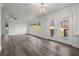 Open living space with windows, gray wood floors, modern light fixture, and doors to a deck at 1892 Buford Dam Rd, Buford, GA 30518