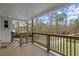 Covered porch with wood decking, stained railing, brick pillars and a view of the yard at 1892 Buford Dam Rd, Buford, GA 30518