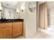 Updated bathroom features granite counters, tile floors, wood cabinets, and shower with curtain at 195 14Th St # 1501, Atlanta, GA 30308