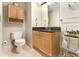 This bathroom features a wooden vanity with a granite countertop, accompanied by a matching wooden cabinet above the toilet at 195 14Th St # 1501, Atlanta, GA 30308