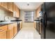 Functional galley kitchen with black appliances, wood cabinets, and a window at 195 14Th St # 1501, Atlanta, GA 30308