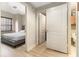 View from bedroom to bathroom featuring a comfortable gray bed, wooden floors, and bright lighting at 195 14Th St # 1501, Atlanta, GA 30309