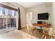 Bright home office with city views from the balcony, wooden desk, and clear modern chairs at 195 14Th St # 1501, Atlanta, GA 30309