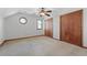 Cozy carpeted bedroom with a ceiling fan, two windows, and a closet with natural wood doors at 195 Willow Way, Stockbridge, GA 30281