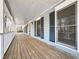 Covered front porch with wooden flooring, white railing, and exterior shutters at 195 Willow Way, Stockbridge, GA 30281