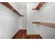 Bright walk-in closet features two sections, wooden floors, with white walls and adjustable shelves at 195 Willow Way, Stockbridge, GA 30281
