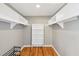 Walk-in closet featuring hardwood floors and built-in shelving at 3734 Fox Hills Se Dr, Marietta, GA 30067