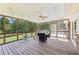 Covered and screened-in back porch featuring a ceiling fan, outdoor seating, and forest view at 3734 Fox Hills Se Dr, Marietta, GA 30067