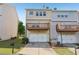 View of the back exterior of this townhome with an attached garage and wooden deck at 1257 Park Pass Way, Suwanee, GA 30024