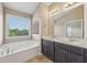 Bright bathroom with double vanity, large tub, and natural light from the window at 1257 Park Pass Way, Suwanee, GA 30024