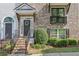 Charming front exterior of townhome with brick stairs and lovely landscaping at 1257 Park Pass Way, Suwanee, GA 30024