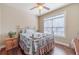 Cozy bedroom with wood-look flooring, a ceiling fan, and a large window with natural light at 255 Nicklaus Cir, Social Circle, GA 30025