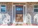 Close-up of a craftsman-style front door with stone surround, sidelights, and decorative accents at 255 Nicklaus Cir, Social Circle, GA 30025