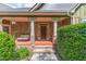 Inviting front porch with stone pillars, seating area, and stylish front door at 255 Nicklaus Cir, Social Circle, GA 30025