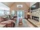Cozy living room showcasing stone fireplace, hardwood floors, and access to screened in deck at 255 Nicklaus Cir, Social Circle, GA 30025
