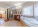 The main bath features a separate shower and soaking tub, with natural light coming through the large window at 255 Nicklaus Cir, Social Circle, GA 30025