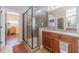 The main bath features a separate shower with frameless glass doors and cherry cabinets at 255 Nicklaus Cir, Social Circle, GA 30025