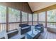 Relaxing screened-in patio featuring comfortable seating and wooded views for enjoying peace and quiet at 255 Nicklaus Cir, Social Circle, GA 30025