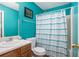 Bright bathroom with turquoise walls, a shower with a patterned curtain, and a vanity with storage space at 3740 Arminto Dr, Ellenwood, GA 30294
