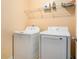 Functional laundry room with a washing machine, dryer, and shelving for storage, optimizing space at 3740 Arminto Dr, Ellenwood, GA 30294