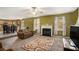 Cozy living room with a fireplace, windows, and a view of the open kitchen and dining space at 3740 Arminto Dr, Ellenwood, GA 30294