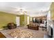 Open-concept living room featuring a fireplace, ceiling fan, and seamless transition to the kitchen and dining area at 3740 Arminto Dr, Ellenwood, GA 30294