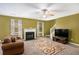 Inviting living room with a fireplace, stairway and natural light, creating a warm and welcoming atmosphere at 3740 Arminto Dr, Ellenwood, GA 30294