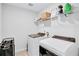 Bright laundry room with modern washer and dryer, and convenient shelving for storage and organization at 4658 Electric Sw Ave, Mableton, GA 30126