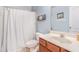 This full bathroom features a single vanity, framed mirror, and shower-tub combo with curtain at 6155 Falls Landing Dr, Cumming, GA 30040