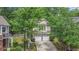 Charming two-story home featuring a two-car garage and a beautifully landscaped front yard with mature trees at 6155 Falls Landing Dr, Cumming, GA 30040