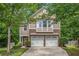 Charming two-story home featuring a two-car garage and a beautifully landscaped front yard with mature trees at 6155 Falls Landing Dr, Cumming, GA 30040